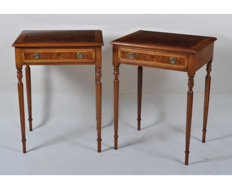 A pair of walnut and figured walnut lamp tables, each having a cross and feather banded top over single frieze drawer, raised
