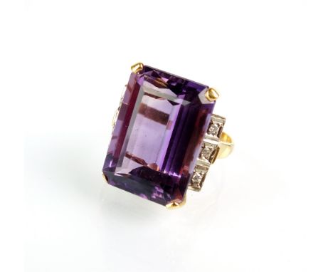An amethyst and diamond dress ring, designed as a large rectangular cut amethyst within four claw setting and flanked to each