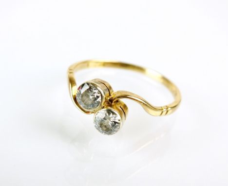 A two stone diamond crossover ring, the two brilliant cut diamonds collet set in yellow metal to yellow metal shank, stamped 