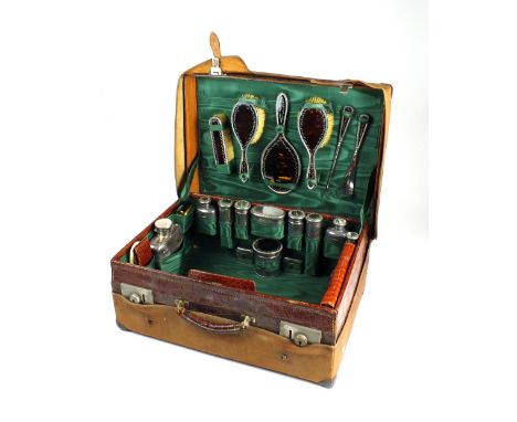 A comprehensive cased silver and tortoiseshell mounted travelling dressing table set, comprising; five silver jars, two silve