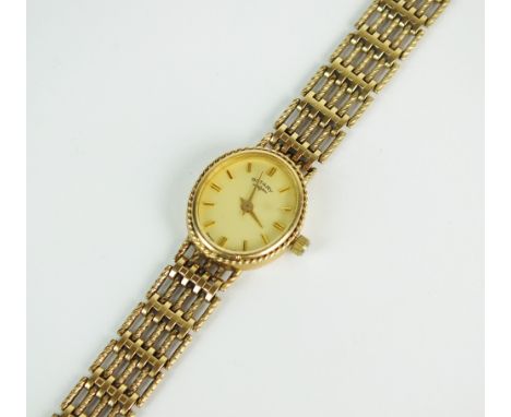 A Lady's 9ct gold Rotary bracelet watch, the oval champagne dial with batons, integral 9ct gold five bar decorative link brac