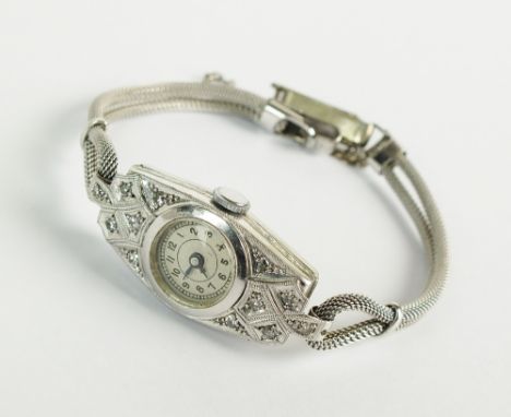 A Lady's diamond set cocktail watch, the plain circular white dial with black Arabic numerals, manual wind, the case stamped 