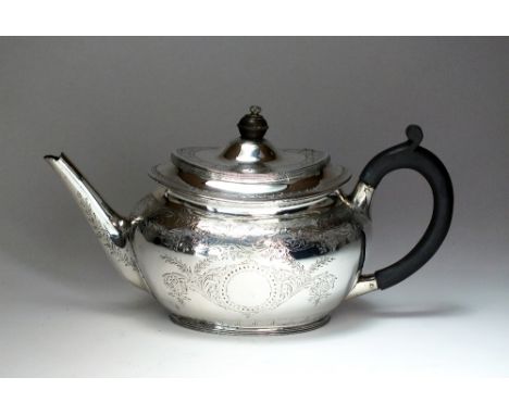 A Victorian silver teapot, Charles Edwards, London 1881, of oval form with bright cut engraved decoration and crest, with ebo