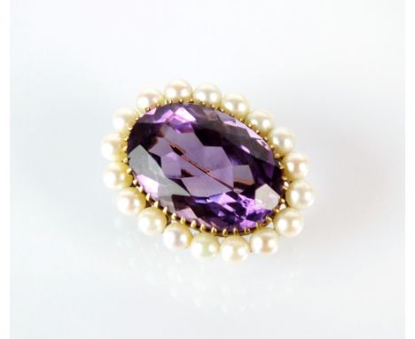 A 9ct gold amethyst and seed pearl cluster brooch, designed as a central oval mixed cut amethyst claw set within a border of 