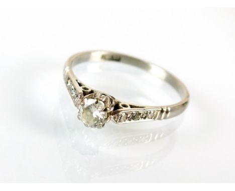 A single stone diamond ring, the brilliant cut diamond claw set in white metal to diamond set shoulders, the shank stamped 'P