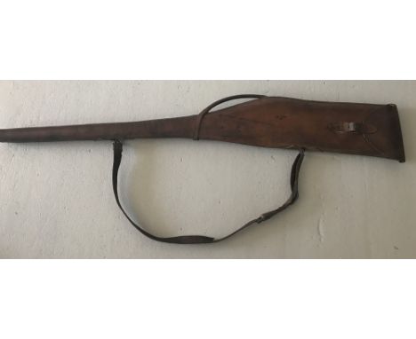 A vintage leather gun case for a side-by-side Shotgun. With carrying handle and shoulder strap. Total length 117cm.