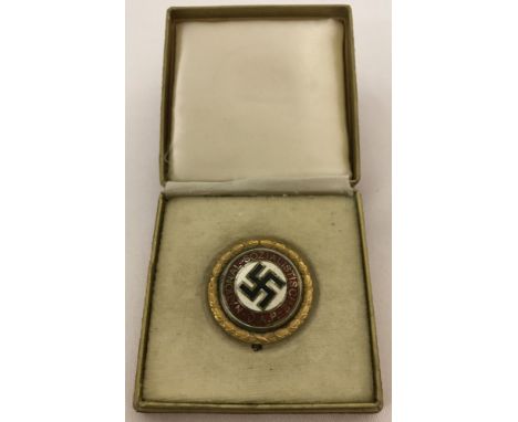 A boxed WW2 style German Gold Award NSDAP pin back party badge.  Approx. 3cm diameter, box approx. 6.5cm².