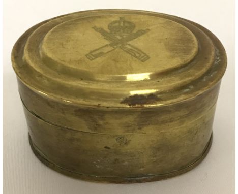A small oval shaped brass "ditty tin" engraved to lid with WW1 style Machine Gun Corps logo.  Approx. 7cm across x 4cm tall.