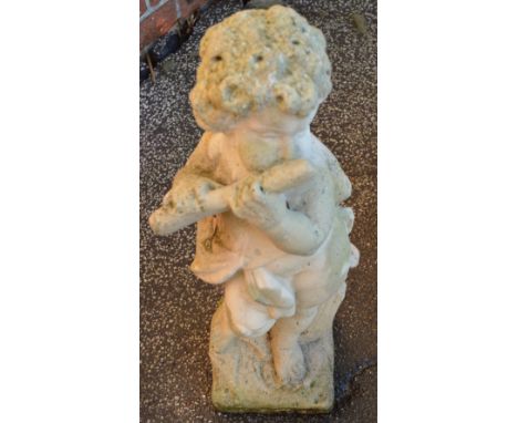 A concrete statue of a boy playing a pipe
