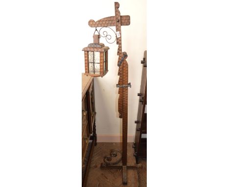 A carved floor standing adjustable hanging lantern