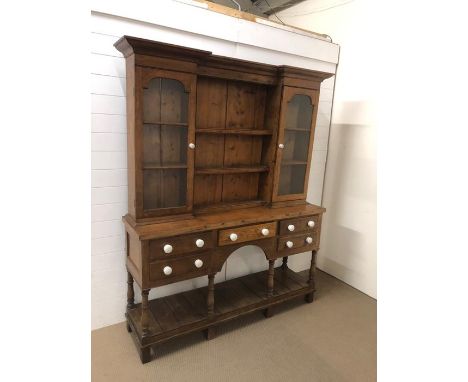 A medium Welsh dresser, pine backed with of two glazed cupboards either side with internal shelving, middle shelves with cup 