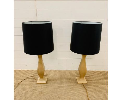A pair of contemporary wooden lamp bases with black shades 