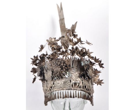 A vintage early 20th-century white metal Chinese wedding headdress, with ornate detailing and hanging cone decoration to the 