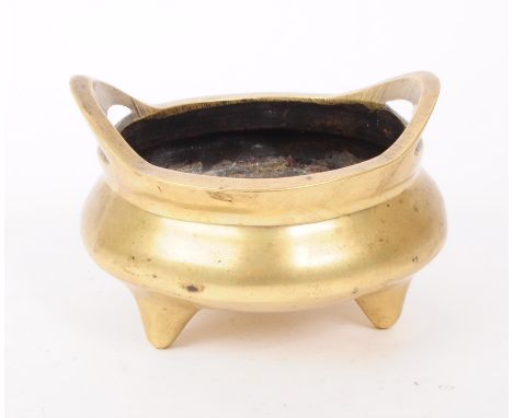 A 19th century Chinese brass open censer incense burner with raised loop handles tripod base with impressed cast caricature m