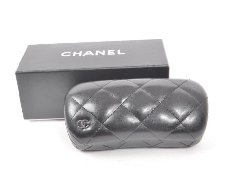 A Chanel black glasses case, with the original box, drawstring bag and paperwork. Measuring approx. 18cm x 7cm x 8cm.