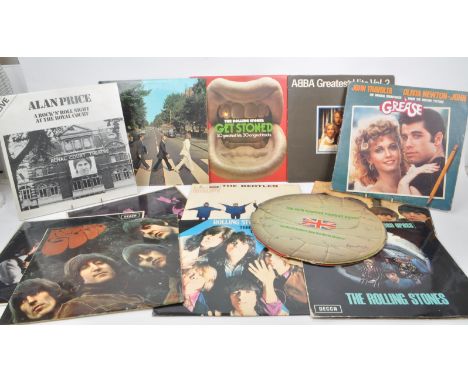 A collection of thirteen vintage 20th century vinyl records, featuring artists such as The Beatles, The Rolling Stones, ABBA,