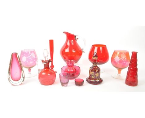 A collection of vintage 20th-century studio art glass pieces, in red, purple, and cranberry. Featuring pieces such as goblets