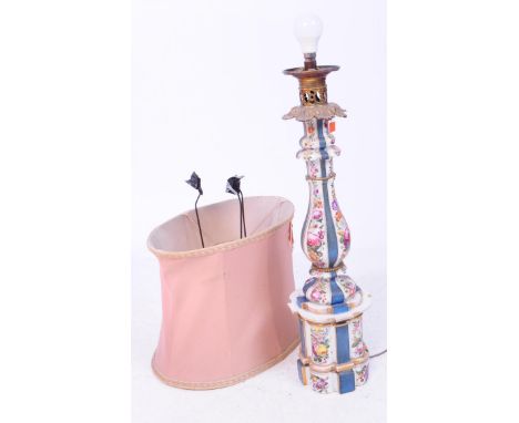 A tall porcelain table lamp with ornate metal head and pale pink lampshade. The porcelain body is decorated in a faux-19th ce