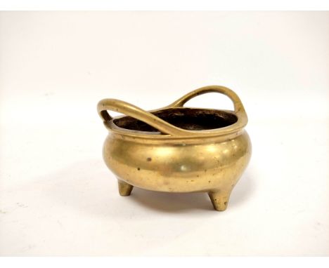Chinese bronze censer in Xuande period style with compressed globular body, twin loop handles on tripod squat feet, cast meda
