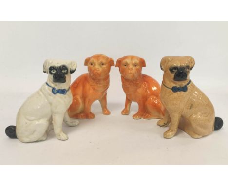 Two early 20th century Staffordshire style ceramic figures modelled as seated pug dogs, with painted eyes, glazed in beige an