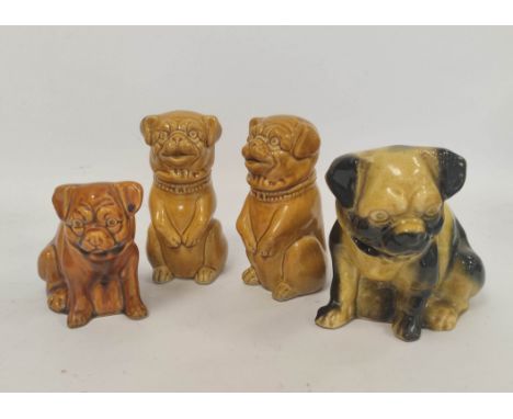 Four early 20th century assorted ceramic pug, and similar, dog models, all in seated poses, to include a pair, 13cm, 16cm, 17
