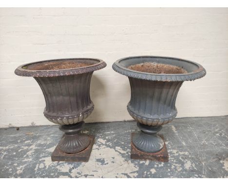 Pair of antique cast iron campagna form garden urns of large size, each with formerly painted lunettes to the border, further
