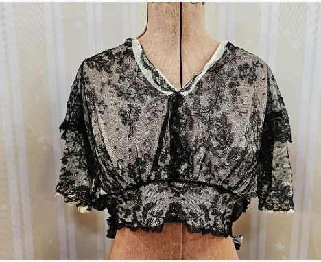A Victorian lace blouse with ties at the waist over white net