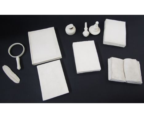 Collection of bisque fired white stoneware desk top objects consisting of five books, an inkwell and quill, magnifying glass 