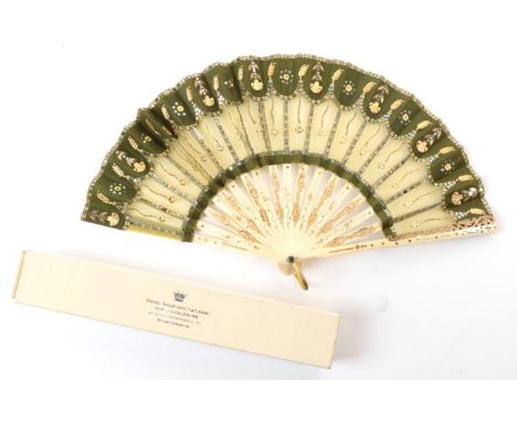 A Small Early 20th Century Spangled Fan, the monture of carved and gilded celluloid. The leaf, of greeny-yellow net, is overl