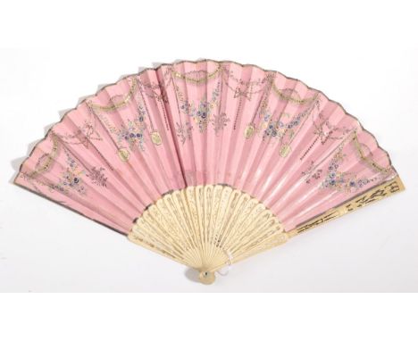 A Late 18th or Early 19th Century Bone Fan, classically carved and pierced. The double leaf, of pink glazed paper, is decorat