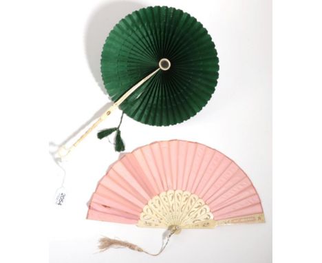 A Bone Handled Parasol Fan, mounted with dark green silk, the handle carved and ending in a shaped loop, the leaf, a cockade,