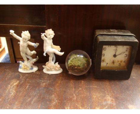   An Ansonia Square Pirate alarm clock, in leather case, 12cm high together with two German ceramic putti and a turf from Lor
