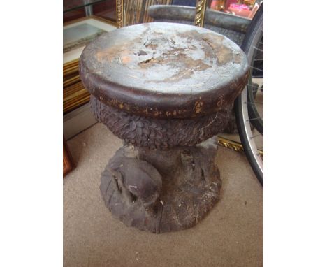 An Eastern stool, carved from a whole trunk depicting elephants circling a tree. 