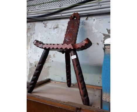 A carved tripod spinning chair. 