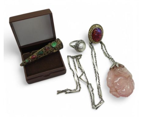 A white metal Thai dancers' finger cover, embellished with gem stones, a rose quartz pendant carved with fruit and leaves, a 
