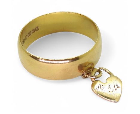 An 18ct gold wide wedding ring with an attached heart charm, size M1/2, weight 4gms Condition Report:Available upon request