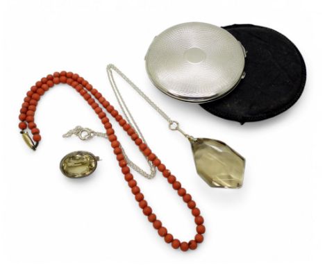 A silver compact with Birmingham hallmarks for 1941, a string of coral beads with a 9ct gold clasp, a silver mounted freeform