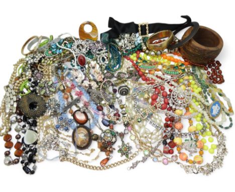 A large collection of vintage costume jewellery to include beads, diamante necklaces, a metal studded statement wooden bangle
