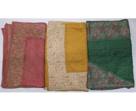 Three 1930s/40s Comfy quilts with central pink paisley diamond with pink surround &amp; paisley border, 216cm x 170cm, a gree