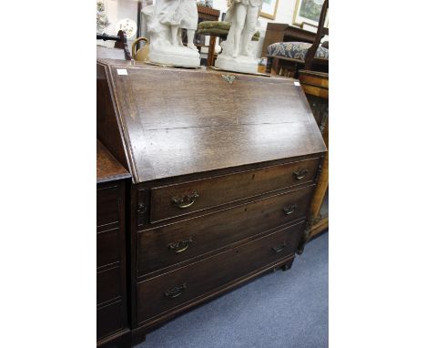 A LATE GEORGIAN OAK WRITING DESK fitted with three drawers below a fall front, standing on bracket feet, 100cm wide x 107cm h