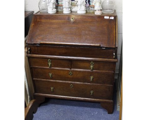 A GEORGIAN STYLE OAK BUREAU fitted with two over two drawers, standing on shaped bracket feet, 79cm wide x 90cm high x 45cm d