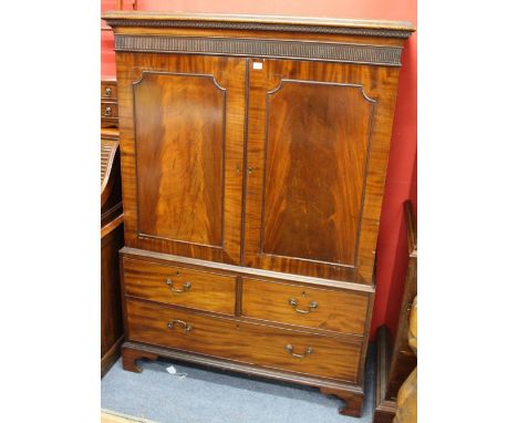 A LATE GEORGIAN MAHOGANY CUPBOARD fitted with two fielded panel doors above two short and one long drawer, standing on shaped