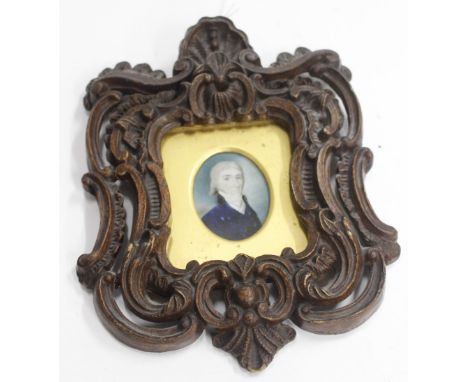 AN ANTIQUE MINIATURE PORTRAIT of a gentleman painted on ivory and mounted in a Rococo style frame 4.5cm x 5cm 