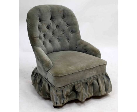 A VICTORIAN LOW OCCASIONAL CHAIR with button upholstered back and arms, turned tapering front legs terminating in ceramic cas