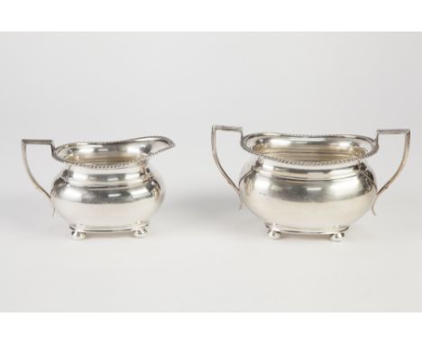 GEROGIAN STYLE SILVER CREAM JUG AND MATCHING TWO HANDLE SUCRIER of squat oval form, the everted rims with applied gadroon dec