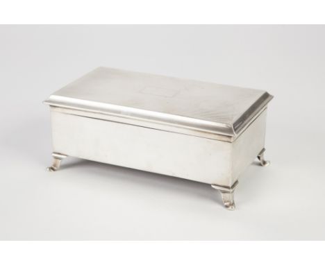 GEO V SILVER CIGARETTE BOX the hinged lid with engine turned decoration and raised on out scroll bracket feet, 7" (17.8) wide