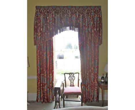 A pair of damask silk lined curtains and matching tasselled pelmet. The fabric decorated with a magenta and gold print, cream