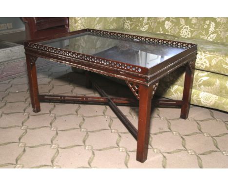 A Chippendale Revival pierced mahogany tray top coffee table. Glass to bottom of top and standing on four squared legs with X