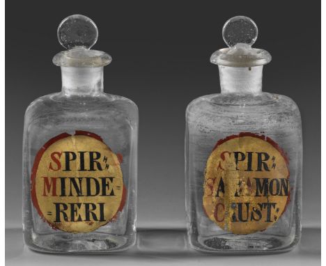 Farbloses Glas. Quadratische Form, gerundete Schulter, kurzer Zylinderhals, auslippender Rand, der Stöpsel mit rundem, abgepl