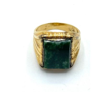 An unmarked yellow metal ring set with rectangular nephrite plaque, 9.6 g, size V